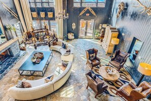 Eine geräumige Lobby mit einer geschwungenen Sitzecke, einem Chandelier und einem Kamin.