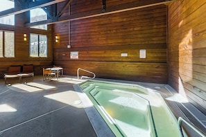 A wooden cabin interior with a hot tub, seating area, and large windows. - Mountain view condo in Cascade Village w/ easy access to trails (Durango)