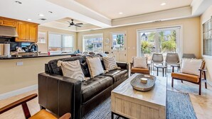 A spacious living area with a leather sofa, a coffee table, and a dining set. - Bright home on the channel with expansive patio & elevator (Long Beach)