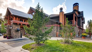 A lodge with a stone facade, wooden beams, and a chimney. - Penthouse Ski-in/Ski-out: hot tubs, heated pool, gym, ski storage, shuttle (Breckenridge)
