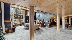 A spacious lobby with a stone floor, wooden ceiling, and large windows. - Penthouse Ski-in/Ski-out: hot tubs, heated pool, gym, ski storage, shuttle (Breckenridge)
