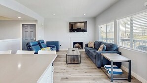 Una sala de estar moderna con chimenea, un sofá, una mesa de centro y un comedor.