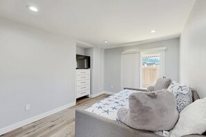 A bedroom with a bed, a dresser, a TV, and a window with blinds. - Updated townhome in gated community  w/ shared pool & jacuzzi - walk to beach (Port Hueneme)