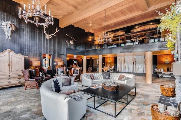 Eine großzügige Lobby mit hoher Decke, Kamin und einer Kronleuchter.