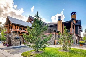 Eine Lodge mit Steinverkleidung, Holzbalken und einem Schornstein.
