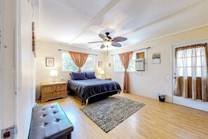 A bedroom with a bed, a ceiling fan, a wooden dresser, a bench, and a rug. - Dog-friendly rural home with deck, wood fireplace, fast WiFi, patio & gas grill (Crestline)