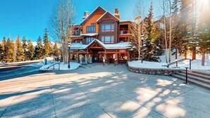 Un chalet doté d’une entrée principale, de plusieurs étages et surplombant un paysage enneigé.