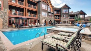 Un hôtel doté d’une piscine, d’un espace extérieur aménagé et d’une façade en pierre.
