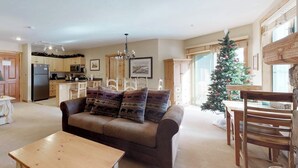 Ein Wohnzimmer mit einer Couch, einem Holztisch und einem Weihnachtsbaum.