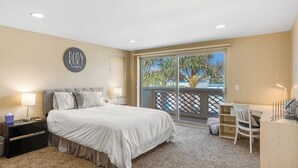 A bedroom with a bed, bedside tables, a desk, and a chair. - Oceanview home with rooftop deck and game room - dog-friendly (Oxnard)