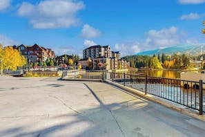 Ein Flussufer-Hotel mit einer Brücke, mehreren Gebäuden und einem Berg im Hintergrund.