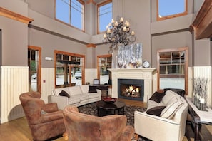 A spacious living area with leather armchairs, a sofa, a fireplace, and a chandelier. - Downtown studio near QuickSilver Super Chair with pool, hot tubs & fireplace (Breckenridge)