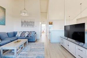 Ein modernes Wohnzimmer mit einer Couch, einem Couchtisch, einem Fernseher und Kunstwerken.
