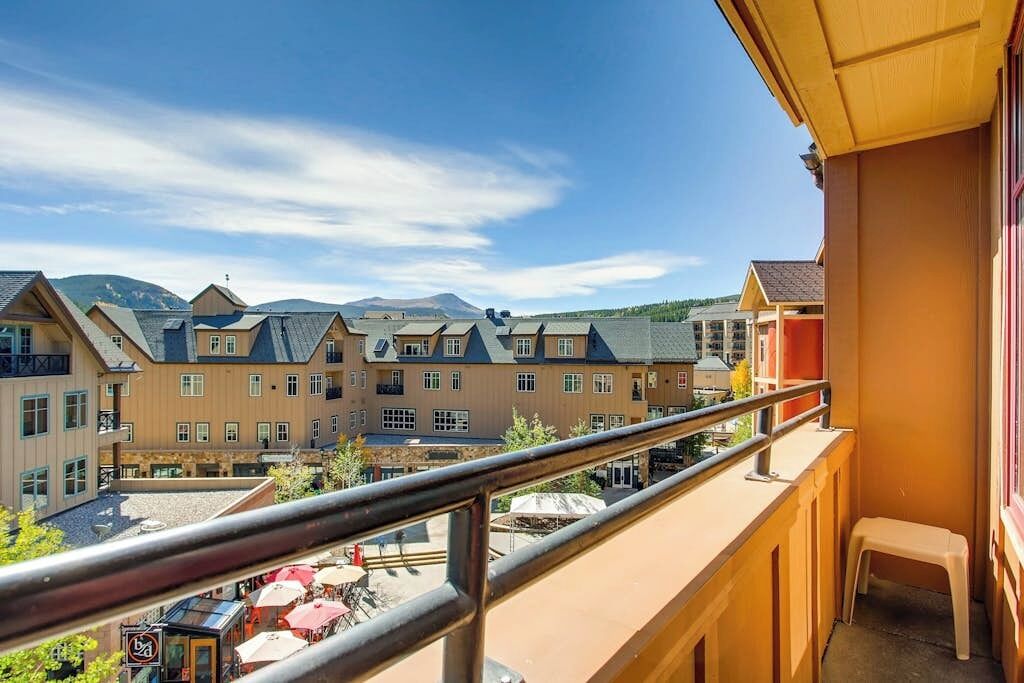 Ein Hotelbalkon mit Blick auf andere Gebäude und einen Berg im Hintergrund.