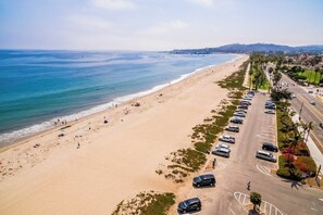 Ein Strand mit Parkplatz und einer Straße parallel zum Ufer.