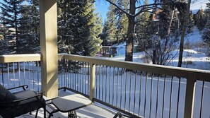 Ein Balkon mit Metallgeländer, einem Stuhl und einem Tisch.
