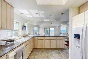 A modern kitchen with a large island, built-in appliances, and a view of the sea. - Lovely House w/Beautiful Ocean Views, Grill & Jetted Tub - Walk  to Beach & Town (Cayucos)