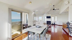 A spacious living area with a dining table, a sofa, and a fireplace.