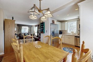Ein Essbereich mit Holztisch und Stühlen, einer Kandelaber und einer Küche im Hintergrund.