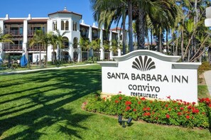 Schild des Restaurants Convivio im Santa Barbara Inn, im Hintergrund ein weißes Gebäude und Palmen.