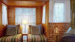 A cozy room with two striped sofas, a small table, and a brick fireplace. - Near Lake Arrowhead Village with loft , Deck & Lake Access Card (Lake Arrowhead)