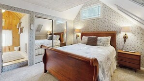 A bedroom with a wooden bed, a mirror, a nightstand, and a window. - Near Lake Arrowhead Village with loft , Deck & Lake Access Card (Lake Arrowhead)