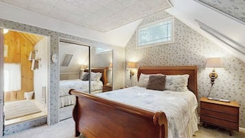 Une chambre à coucher avec un lit en bois, un miroir, une table de chevet et une fenêtre.