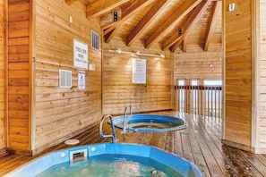Ein Holz-Spa mit zwei Whirlpools, Holzwänden und einer Holzterrasse.