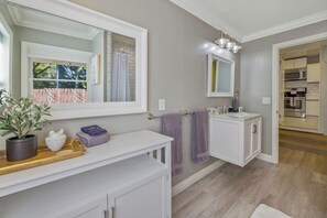 A bathroom with a large mirror, a sink, a towel rack, and a potted plant. - Downtown home w/private hot tub, pool table, gas grill, W/D, AC (Paso Robles)
