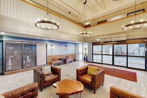 A spacious lobby with leather furniture, large windows, and a view of the outside. - Cozy Condo with Stunning Mountain Views, Hot Tub, and Fireplace (Crested Butte)