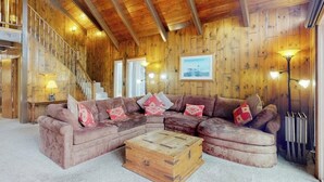 Un intérieur en bois comprenant un canapé, une commode en bois et un escalier.