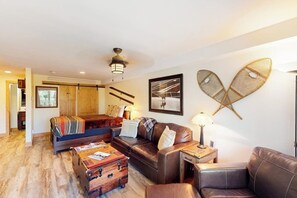 Ein Wohnzimmer mit Sofa, Couchtisch, Lampe und einem Wanddekor.