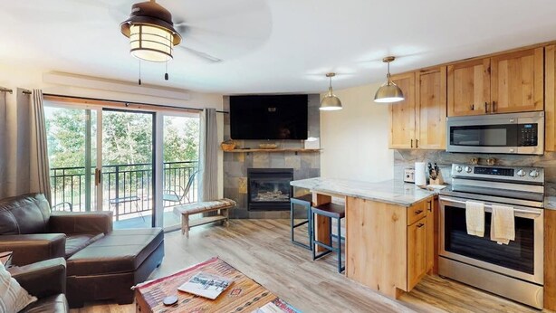 Una cocina moderna con armarios de madera, un microondas integrado y una chimenea.