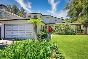 Ein zweistöckiges Haus mit Garage, rotem Eingang und gepflegtem Rasen.