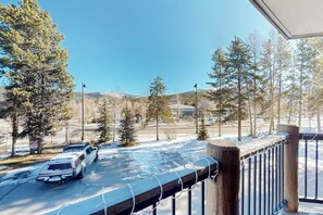A parking lot with snow on the ground, trees, and a mountain in the background. - Mountain view condo with hot tub, walk to Snowflake Lift & Main Street (Breckenridge)