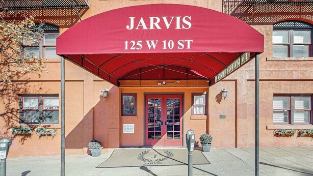 Entrada de un edificio con toldo rojo que dice 'JARVIS 125 W 10 ST'.