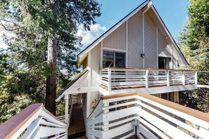 Un bâtiment à deux étages doté d’une terrasse en bois et d’un escalier menant à l’étage supérieur.