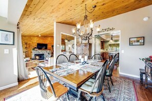 Ein Esszimmer mit Holztisch, Stühlen und einer Chandelüster.