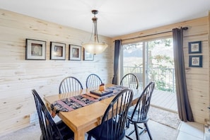 A wooden-paneled room with a dining table, chairs, and framed pictures on the wall. - Beautiful mountain home steps to ski slopes with fireplace (Durango)
