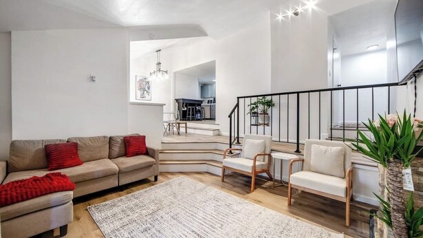 A modern living room with a sofa, chairs, a staircase, and a dining area. - Dog-friendly Arrowhead Villas cottage with deck, fireplace & W/D- great locale (Lake Arrowhead)