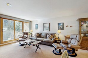 Ein Wohnzimmer mit einer Couch, Sesseln, einem Couchtisch und einem Massagesessel.