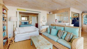 Une pièce confortable avec un lit, un canapé, une petite table et une bibliothèque.