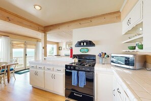 A kitchen with white cabinets, a black stove, and a microwave.