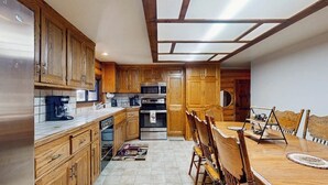 Una cocina con armarios de madera, una mesa de comedor y un microondas.