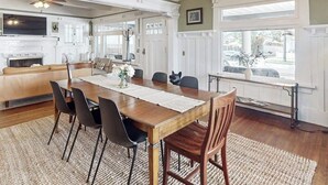 A dining area with a wooden table, black chairs, and a chandelier. - Old Yacht Club Inn All-Suite Getaway - 1 Block to East Beach, Walk Everywhere (Santa Barbara)