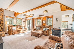 Ein geräumiges Wohnzimmer mit Ledersofas, einem Couchtisch und einem Kamin.