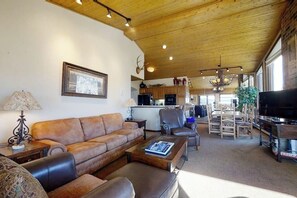 Ein Wohnzimmer mit einer Couch, einem Couchtisch und einem Fernseher.