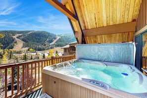 Ein Whirlpool auf einem Balkon mit Blick auf eine Berglandschaft.