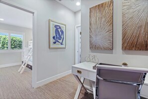 A modern room with a desk, chair, artwork, and a view through a window. - Newly renovated condo, closest walk to theme parks - pools & hot tub on-site (Anaheim)