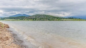 Een rivier met een eiland begroeid met bos en bergen op de achtergrond.
